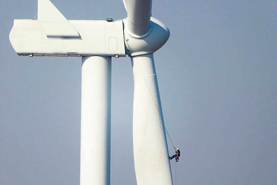 Worker climbing on of a wind turbine
